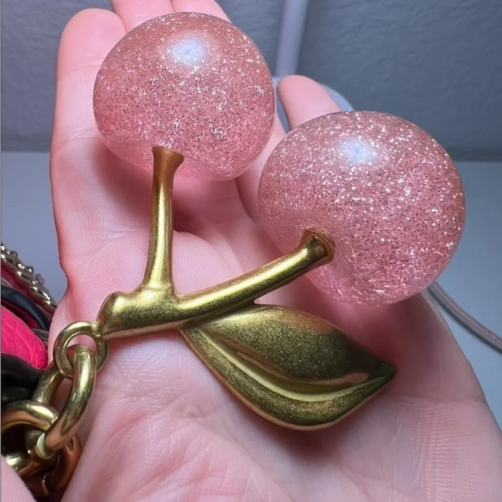 Cherry Pink sparkles with gold leaf clips onto your coach purse